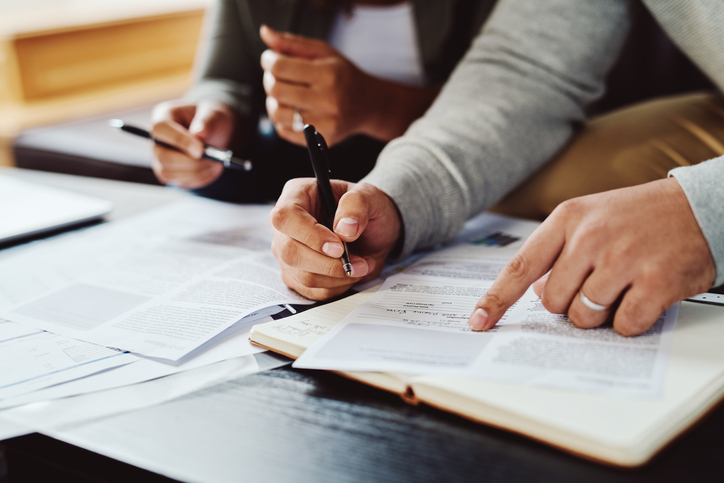 Two people comparing Homeowners Warranty papers