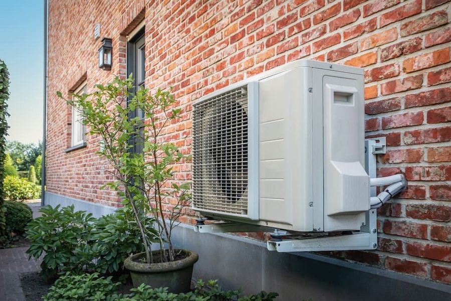 Heat pump installed on the side of a brick home