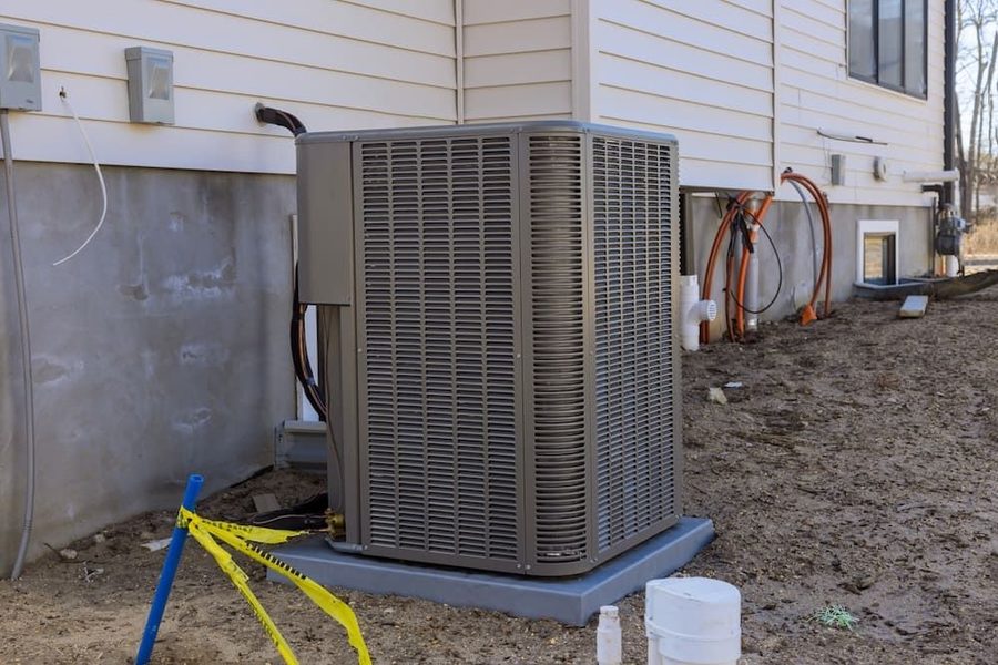 Outdoor air conditioning unit on a concrete slab next to the house